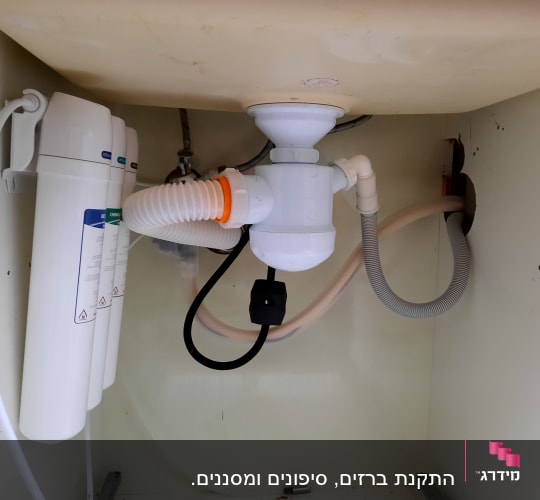 צנרת מתחת לכיור עם מסנן מים ומחברים